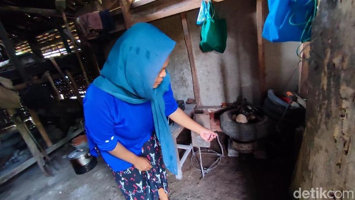 Ai Reni menunjukkan lokasi ular jenis King Kobra bersembunyi di dapur rumahnya.