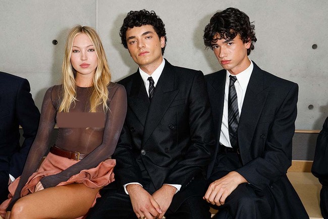 Duduk di front row peragaan Saint Laurent Menswear Spring/Summer 2026, Lila berpose bersama rekan sesama model, Antoine Waldner dan Hugo Dacquet. Foto: Aitor Rosas Sune/WWD via Getty Images