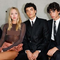 Duduk di front row peragaan Saint Laurent Menswear Spring/Summer 2026, Lila berpose bersama rekan sesama model, Antoine Waldner dan Hugo Dacquet. Foto: Aitor Rosas Sune/WWD via Getty Images