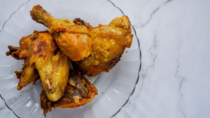 A closeup shot of a bowl of deep fried chicken marinated with turmeric and salt