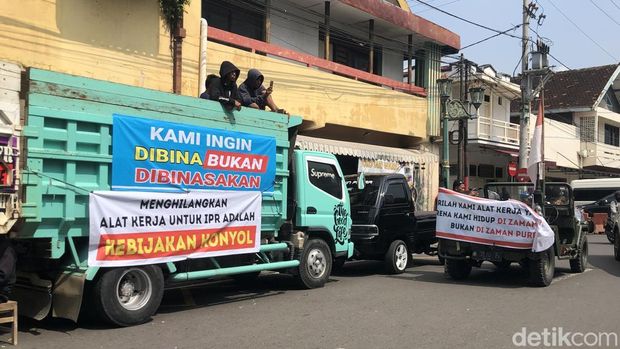 Massa membentangkan spanduk protes di truk saar aksi di Kompleks Kepatihan, Jogja, Rabu (25/6/2025).