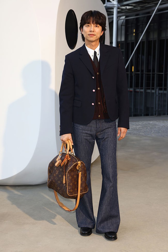 Gong Yoo telah bergabung sebagai global ambassador Louis Vuitton tahun lalu. Bintang drama Korea Trunk itu menampilkan gaya klasik di Paris Fashion Week 2025, memakai setelan kemeja putih, vest maroon, blazer navy, yang dipadukan dengan denim jeans, boots dan koleksi tas Louis Vuitton. Foto: Getty Images