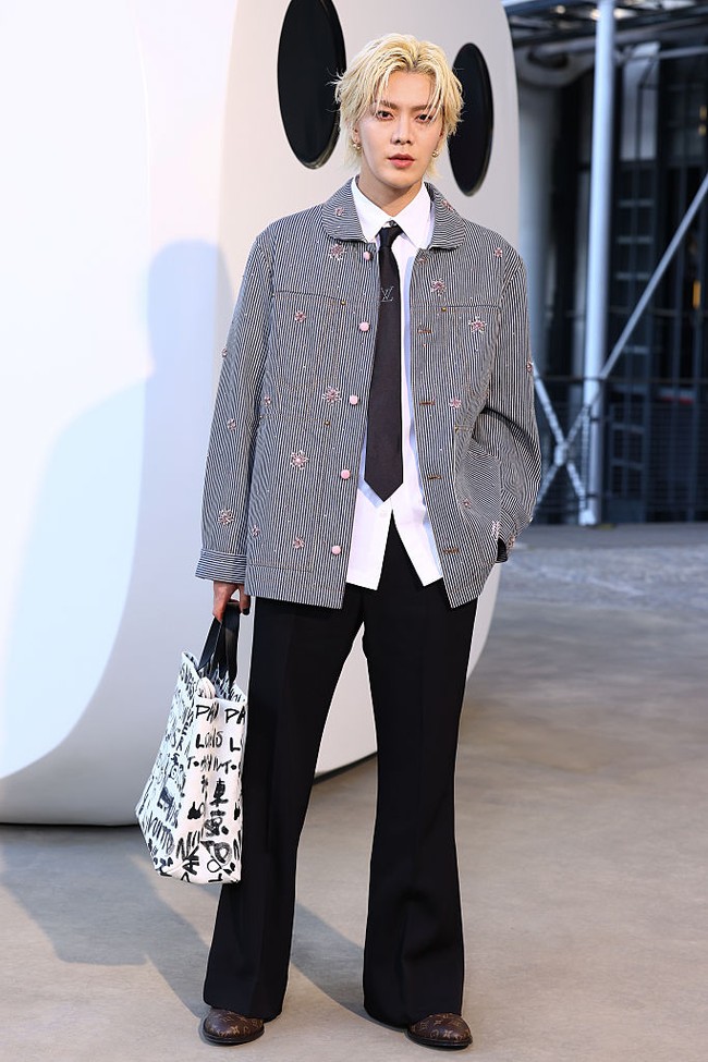 Personel grup KPop NCT asal Jepang, Yuta tak kalah eksis, langganan hadir di peragaan busana Louis Vuitton. Yuta memakai jaket garis-garis dengan detail kancing dan bordiran berwarna pink yang dipadukan dengan celana berpotongan cutbray. Pelantun ‘Kick It’ itu juga menjinjing koleksi totebag LV berwarna monokrom. Foto: Getty Images