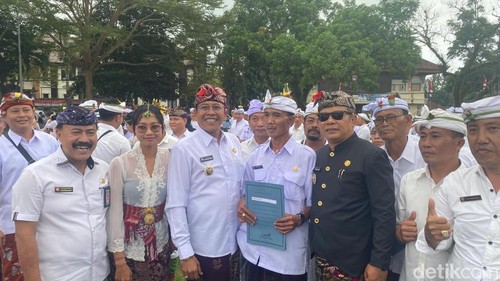 I Wayan Tusta (memegang map biru) berfoto bersama Bupati dan Wakil Bupati Karangasem di Lapangan Tanah Aron, Karangasem, Rabu (25/6/2025). (Foto: I Wayan Selamat Juniasa/detikBali)