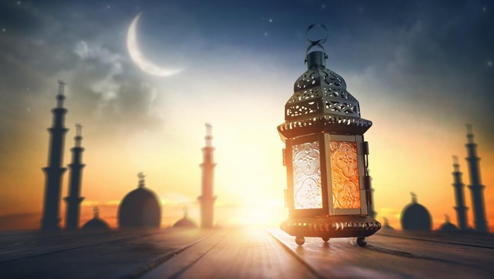 Ornamental Arabic lantern with burning candle glowing at night. Festive greeting card, invitation for Muslim holy month Ramadan Kareem.