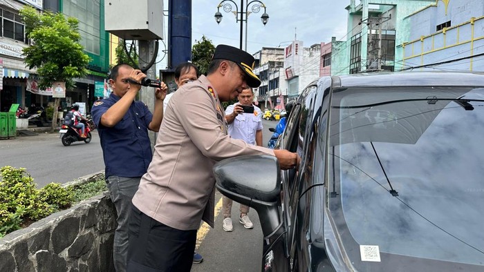Kapolres Lubuklinggau bersama jurnalis membagikan tanda mata kepada masyarakat kota Lubuklinggau