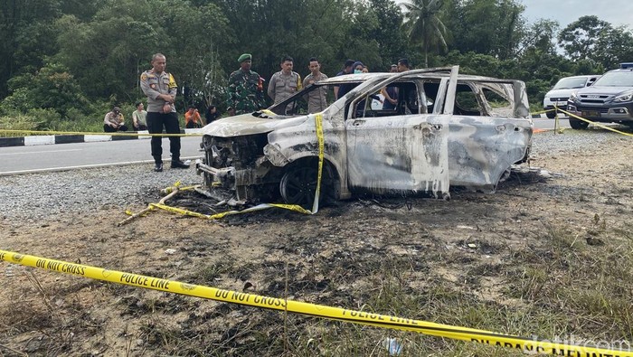 Polisi melakukan evakuasi jenazah korban terbakar di mobil.