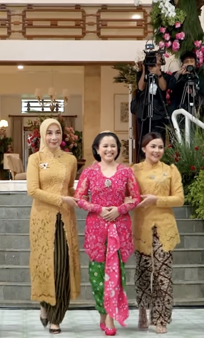 Dhila, sapaan akrab wanita 27 tahun itu tampil dalam balutan kebaya pink fuschia dengan kain jumputan berwarna hijau. Berjalan ke arah ayah dan ibunya, Dhila tampil bersahaja dengan sanggul bangun tulak, khas Solo.  Foto: dok. Instagram @pramonoanungw
