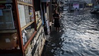 Meski air merendam sejumlah ruas jalan, aktivitas warga tetap berlangsung seperti biasa. ANTARA FOTO/Bayu Pratama S
