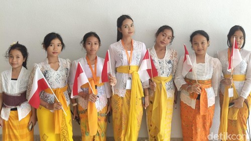 Siswa dari SD 2 Peliatan, Ubud bersiap menyambut kedatangan Presiden Prabowo di The Meru Sanur, Denpasar, Bali pada Rabu (25/6/2025)