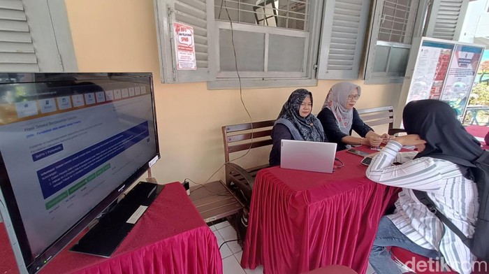 Calon wali murid tengah memantau SPMB di SMP N 1 Purwokerto, Rabu (25/6/2025).