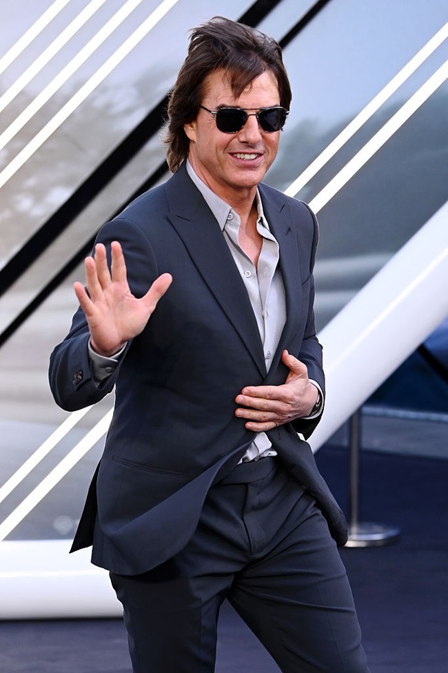 Tom Cruise memilih setelan jas yang lebih simple, nuansa monokrom abu-abu gelap dan muda. Foto: Getty Images/Joe Maher