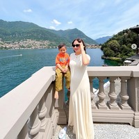 Berpose bersama Rayyanza dengan latar belakang danau di Italia, Nagita tampil dengan dress putih panjang dari brand Swedia, Toteme. Menurut Instagram fanpage Nagita Slavita, dress tersebut merupakan Fluid Jersey Maxi T-shirt Dress dan dijual seharga Rp 9,7 juta. Foto: Dok. Instagram RaffiNagita