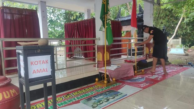 Penjaga Makam Prabu Tawang Alun membersihkan makam.