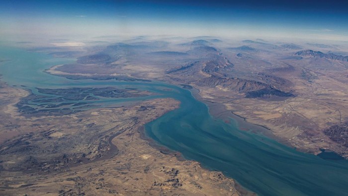 Potret Selat Hormuz, Titik Rawan Jalur Minyak Dunia FILE PHOTO: An aerial view of the Iranian shores and the island of Qeshm in the strait of Hormuz, December 10, 2023. REUTERS/Stringer/File Photo