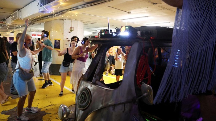 Potret Warga Israel Gelar Pesta Musik di Bunker Kala Iran Menyerang People dance in a headphones party inside a public shelter in an underground parking of a mall amid the Israel and Iran conflict in Tel Aviv, Israel June 23, 2025 REUTERS/Itai Ron ISRAEL OUT. NO COMMERCIAL OR EDITORIAL SALES IN ISRAEL TPX IMAGES OF THE DAY