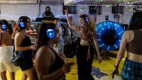 Dalam foto yang diambil pada Senin (23/6), warga pengungsi Israel menggelar pesta musik dengan headphone dan berdansa di dalam tempat parkir bawah tanah yang kini jadi bunker perlindungan. Foto: REUTERS/Itai Ron