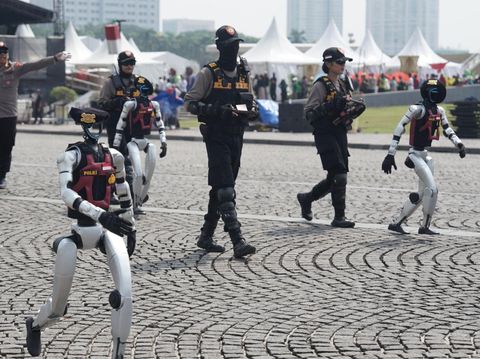 Puluhan robot mondar-mandir di kawasan silang Monas, Kamis (26/6/2025). Kehadiran robot-robot ini mengundang perhatian masyarakat. Robot-robot ini akan memeriahkan Hari ke-79 Bhayangkara pada 1 Juli 2025.