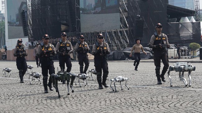 Puluhan robot mondar-mandir di kawasan silang Monas, Kamis (26/6/2025). Kehadiran robot-robot ini mengundang perhatian masyarakat. Robot-robot ini akan memeriahkan Hari ke-79 Bhayangkara pada 1 Juli 2025.