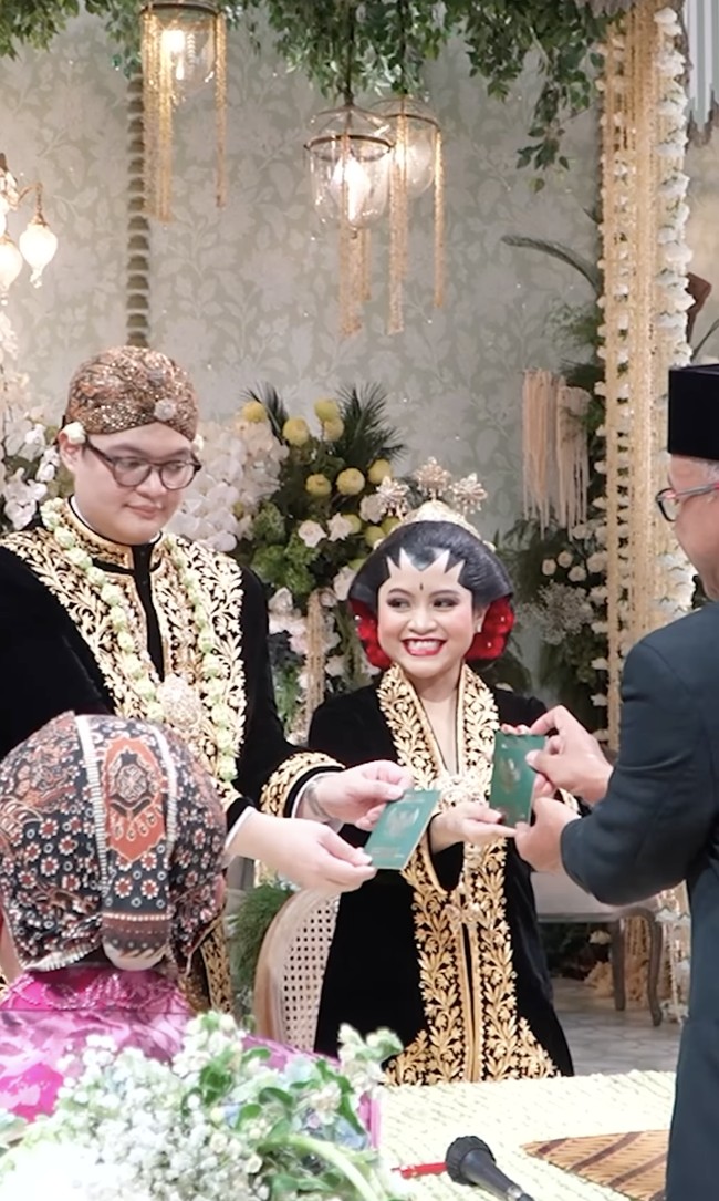 Ariq pun tak kalah gagah. Ia mengenakan beskap bludru berwarna senada, lengkap dengan kain jarik dan blangkon sebagai penutup kepala. Penampilan pasangan ini seolah membawa tamu undangan menyaksikan pernikahan agung ala keraton. Foto: dok. Instagram/@pramonoanungw