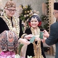 Ariq pun tak kalah gagah. Ia mengenakan beskap bludru berwarna senada, lengkap dengan kain jarik dan blangkon sebagai penutup kepala. Penampilan pasangan ini seolah membawa tamu undangan menyaksikan pernikahan agung ala keraton. Foto: dok. Instagram/@pramonoanungw