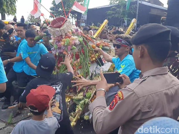 Rebutan gunungan di kirab haul makam Nyai Ageng Ngerang, Desa Tambakromo, Pati, Kamis (26/6/2025).