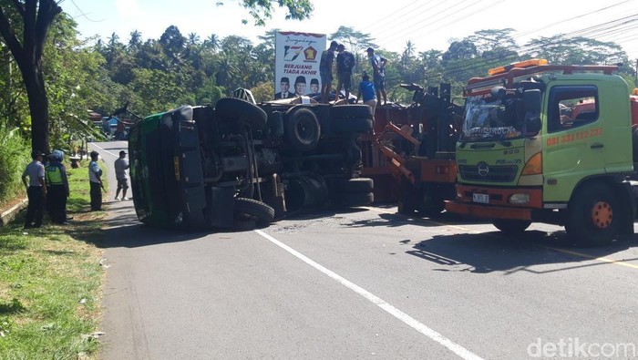 Truk trailer masih melintang di tengah jalan. Forklift menurunkan muatan gulungan kertas dari truk trailer tersebut, Kamis (26/6/2025).
