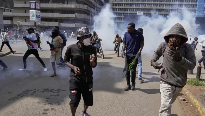 Protesters scatter as police fire teargas at them during a demonstration on the one-year anniversary of deadly anti-tax demonstrations in downtown Nairobi, Kenya, Wednesday, June 25, 2025. (AP Photo/Brian Inganga)