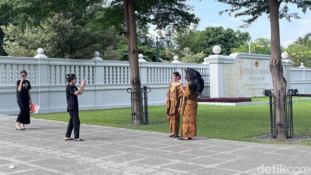 Wisatawan berfoto dengan baju adat di kawasan Malioboro, Jogja, Jumat (27/6/2025).