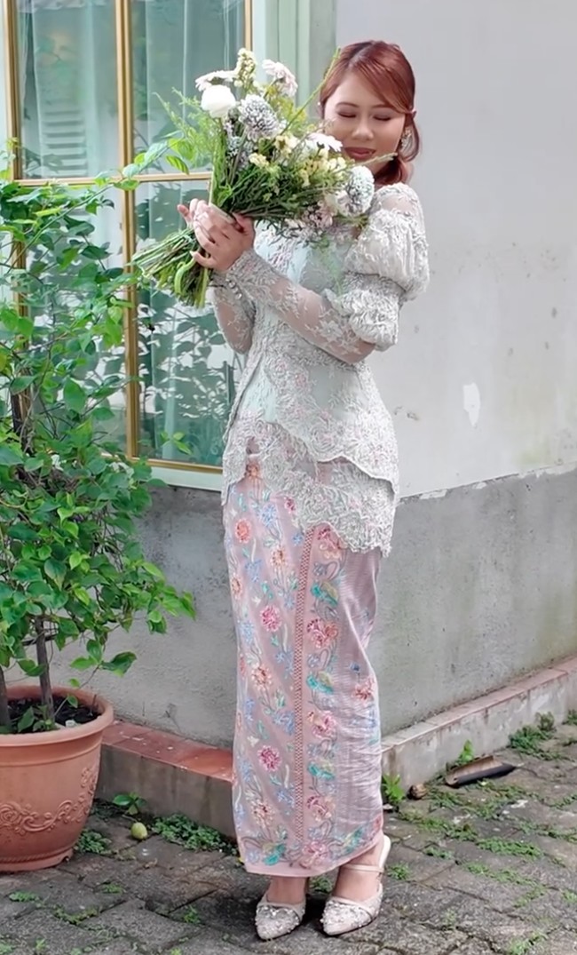 Nadin tampil mengenakan kebaya berwarna hijau pastel yang memberi kesan tenang, mewah, dan klasik. Dipercantik dengan bordir motif floral berwarna pink lembut, memberikan kesan feminin dan romantis. Sebagai bawahan, Nadin memilih kain batik panjang motif floral dengan warna pastel senada. Foto: Instagram/@cakecaine/@vidialdiano