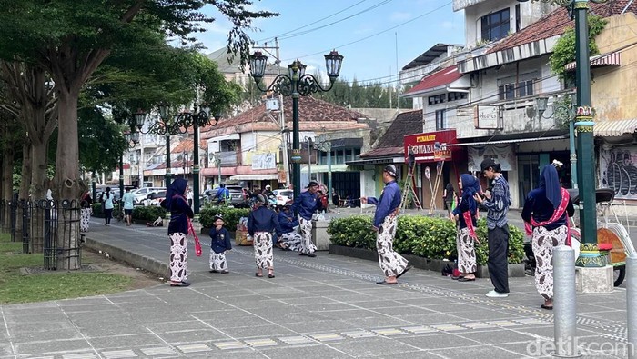 Rombongan wisatawan menggunakan baju adat di kawasan Malioboro, Jogja, Jumat (27/6/2025).