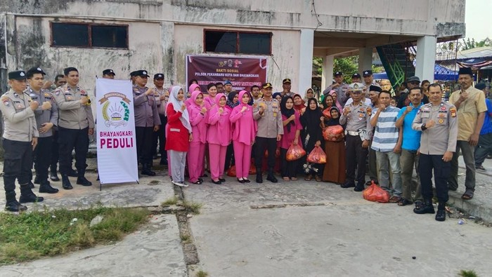 Polsek Pekanbaru Kota membagikan sembako dan pohon kepada warga di HUT Bhayangkara ke-79, pada Kamis (26/6/2025).