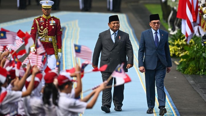 Presiden Prabowo Subianto (tengah) berjalan bersama Perdana Menteri Malaysia Anwar Ibrahim (kanan) saat menginspeksi pasukan dalam upacara kenegaraan di Istana Merdeka, Jakarta, Jumat (27/6/2025). Kunjungan kenegaraan PM Malaysia Anwar Ibrahim di Istana Kepresidenan Jakarta tersebut untuk membahas hubungan bilateral, tindak lanjut dari sejumlah agenda ASEAN di Kuala Lumpur beberapa waktu lalu, serta bertukar pandangan soal dinamika kawasan dan global yang menjadi perhatian bersama. ANTARA FOTO/Hafidz Mubarak A/app/nym.