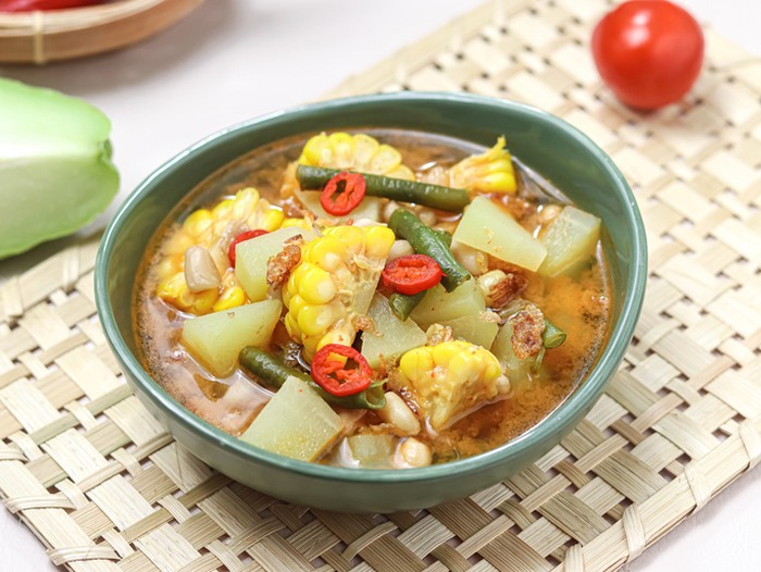 Sayur Asam or Sayur Asem or Tamarind Soup is a popular traditional Indonesian soup with corn, chayote, cabbage and long beans, eggplant, melinjo or belinjo (Gnetum gnemon) leaves. Served in a bowl. isolated.