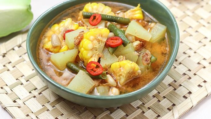 Sayur Asam or Sayur Asem or Tamarind Soup is a popular traditional Indonesian soup with corn, chayote, cabbage and long beans, eggplant, melinjo or belinjo (Gnetum gnemon) leaves. Served in a bowl. isolated.