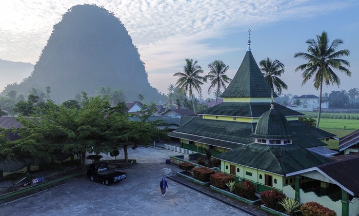Surau tuo Taram di Limapuluhkota Warga melintas di halaman cagar budaya Surau Tuo Taram, Limapuluhkota, Sumatera Barat, Jumat (27/6/2025). Surau yang didirikan pada awal abad ke-17 oleh Syekh Ibrahim Mufti itu dulunya merupakan pusat peradaban Islam tertua di Luak Limopuluah (daerah Limapuluhkota dan sekitarnya). ANTARA FOTO/Iggoy el Fitra/bar