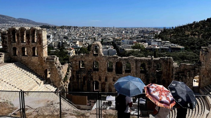 Athena Kepanasan! Turis Berlindung di Tengah Suhu Ekstrem Gelombang panas ekstrem melanda Athena, Yunani, pada Jumat (27/6/2025), memaksa warga dan wisatawan mencari cara bertahan di tengah suhu yang membakar. REUTERS/Stelios Misinas