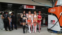 Kehadiran umbrella girl menjadi bagian tak terpisahkan dari tradisi SuperGT, memberikan warna tersendiri dan menarik perhatian penonton di sela-sela ketatnya persaingan para pembalap memperebutkan podium. Dina Rayanti/DetikOto