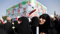 Massa membawa poster dan bendera, meneriakkan yel-yel anti-Israel sebagai bentuk protes atas serangan yang dianggap melanggar kedaulatan Iran. REUTERS/Majid Asgaripour