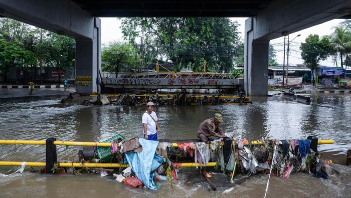 Seorang anak melintasi banjir di bawah Jalan Layang Cibodas, Kota Tangerang, Banten, Minggu (29/6/2025). Kolong jalan layang tersebut terendam banjir akibat luapan Kali Sabi yang dipicu tingginya intensitas hujan hingga membuat akses jalan warga dari Cimone menuju Uwung Jaya maupun sebaliknya terhambat. ANTARA FOTO/Putra M. Akbar/tom.