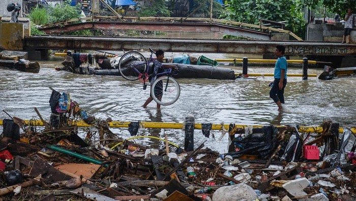 Banjir Rendam Kolong Jalan Layang Cibodas, Akses Warga Terganggu Seorang anak melintasi banjir di bawah Jalan Layang Cibodas, Kota Tangerang, Banten, Minggu (29/6/2025). Kolong jalan layang tersebut terendam banjir akibat luapan Kali Sabi yang dipicu tingginya intensitas hujan hingga membuat akses jalan warga dari Cimone menuju Uwung Jaya maupun sebaliknya terhambat. ANTARA FOTO/Putra M. Akbar/tom.
