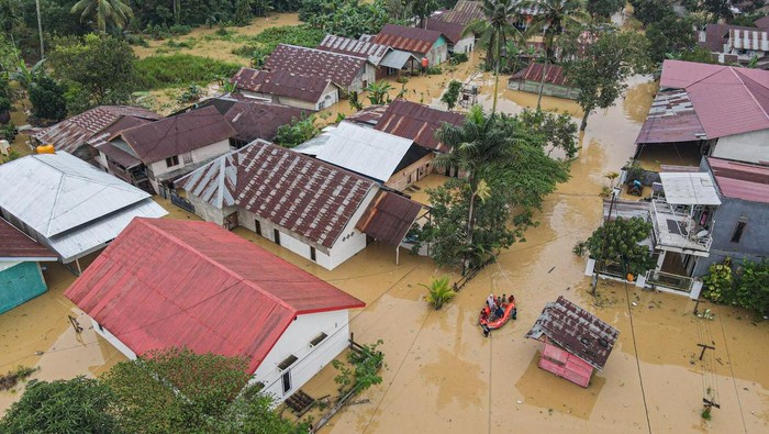 Foto udara petugas menggunakan perahu karet mengevakuasi warga terdampak banjir di Kelurahan Lepo-lepo, Kendari, Sulawesi Tenggara, Minggu (29/6/2025). Banjir yang merendam puluhan rumah di wilayah itu disebabkan meluapnya Kali Wanggu setelah diguyur hujan intensitas tinggi sejak Sabtu (28/6/2025). ANTARA FOTO/Andry Denisah/rwa.