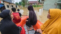 Warga mengevakuasi diri menggunakan perahu karet dari luapan Kali Wanggu. Banjir itu merendam puluhan rumah. Foto: ANTARA FOTO/Andry Denisah