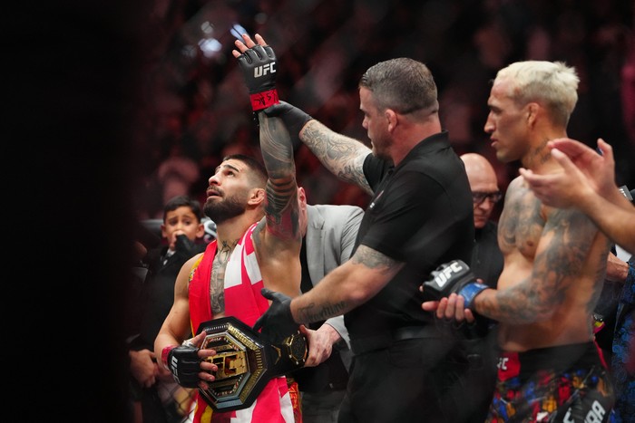 Jun 28, 2025; Las Vegas, Nevada, USA; Ilia Topuria (red gloves) reacts after the fight against Charles Oliveira (blue gloves) during UFC 317 at T-Mobile Arena. Mandatory Credit: Stephen R. Sylvanie-Imagn Images