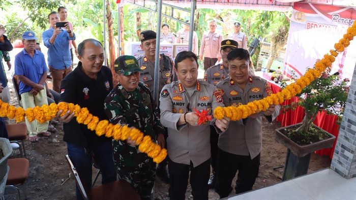 Kabid Humas Polda Bali, Kombes Ariasandy, memotong pita peresmian bedah rumah di Banjar Nusasari, Desa Nusasari, Kecamatan Melaya, Jembrana, Minggu (29/6/2025). (Dok. Polda Bali)