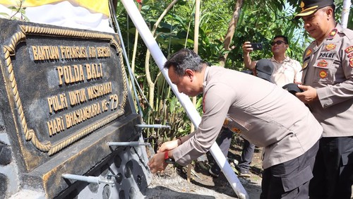 Kabid Humas Polda Bali, Kombes Ariasandy, mencuci tangan dari air yang disalurkan melalui bantuan pipa air bersih bantuan Polda Bali di Banjar Pangkung Lubang, Desa Pergung, Kecamatan Mendoyo, Jembrana, Minggu 29/6/2025. (Dok. Polda Bali)
