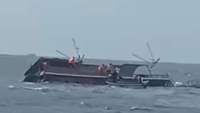 Pinisi Angin Mamiri tenggelam diterjang gelombang di perairan TN Komodo, Manggarai Barat, NTT, Minggu (29/6/2025) siang. (Tangkapan layar video)