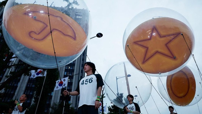 Performers dressed as 'Squid Game' soldiers stand with Squid Game-themed coffins, before a parade through central Seoul, followed by a fan event with cast to celebrate the release of the third season of Netflix's hit series, in Seoul, South Korea, June 28, 2025. REUTERS/Kim Soo-hyeon