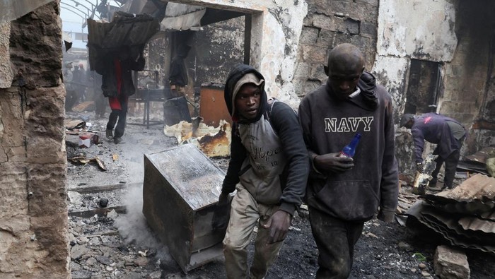 Toko-toko di Kenya Rusak Parah Usai Aksi Protes Mematikan People salvage metal from the premises of businesses burnt during demonstrations to mark the first anniversary of the deadly 2024 anti-government protests that drew widespread condemnation over the use of force by security agencies, in downtown Nairobi, Kenya June 26, 2025. REUTERS/Monicah Mwangi