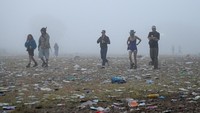 Sejumlah orang berjalan melintasi area Worthy Farm yang dipenuhi sisa-sisa perayaan usai penutupan Glastonbury Festival di Pilton, Somerset, Inggris, Senin (30/6/2025). REUTERS/Jaimi Joy